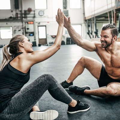Mann und Frau klatschen im Fitnessstudio ab