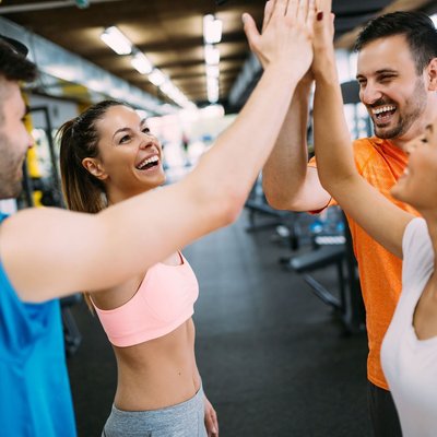 Gruppe klatscht im Fitnessstudio ab